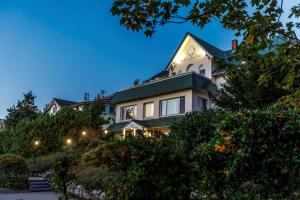 ein großes weißes Haus mit grünem Dach in der Unterkunft Hotel See-Villa in Malente