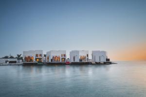 فندق سوفتيل زلاق البحرين في المنامة: مجموعة مباني على الماء وقت الغروب