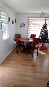 a dining room with a table and a christmas tree at Casa Her Pto Montt 3Dorm in Llanquihue