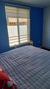 a bedroom with a large bed with a window at Casa Her Pto Montt 3Dorm in Llanquihue