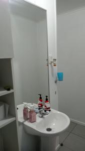 Baño blanco con lavabo y espejo en Casa Her Pto Montt 3Dorm, en Llanquihue