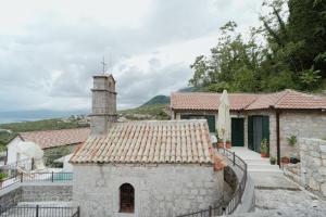 a house with a tile roof and a tower at Casa di Pietra in Kotor