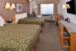 a hotel room with two beds and a desk at Canadas Best Value Inn Valemount in Valemount
