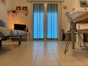 een woonkamer met blauwe gordijnen en een open haard bij Romea in Rosolina Mare