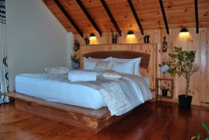 een slaapkamer met een groot wit bed en houten vloeren bij Cottage by Tranquil in Nuwara Eliya