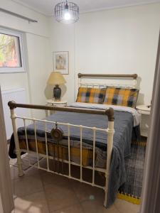 a bedroom with a bed and a lamp on a table at Alonaki House in Amfiklia