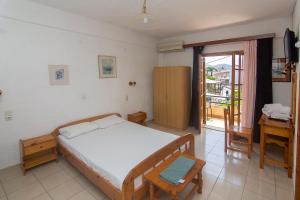 a bedroom with a bed and a desk and a window at Thaleia view in Perdika