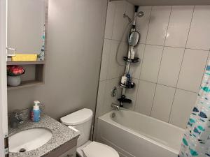 a bathroom with a toilet and a sink and a tub at 1-bedroom condo near University of Waterloo in Waterloo