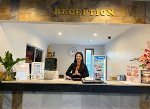 a woman sitting at a counter in a store at Siam Boutique Hotel โรงแรมสยามบูทีค in Buriram