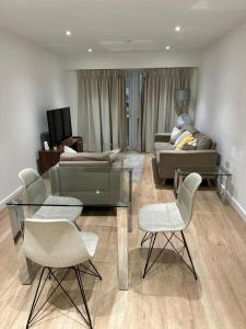 a living room with a couch and a table and chairs at Stunning 1-Bed Apartment in London in Hendon
