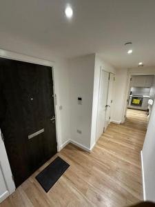 um quarto vazio com uma porta preta e pisos de madeira em Stunning 1-Bed Apartment in London em Hendon