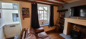 a living room with a couch and a fireplace at Church Street Cottage in Staithes