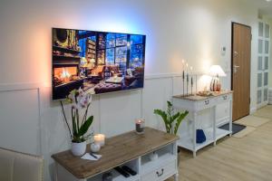 uma sala de estar com uma televisão de ecrã plano na parede em Maya's Flats & Resorts 56 - Szafarnia em Gdansk