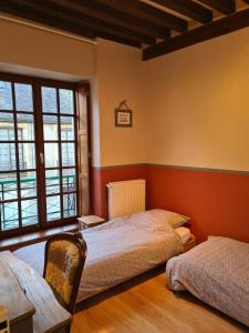 1 dormitorio con 2 camas y ventana en Le petit Conté - Maison calme en centre ville, en Sées