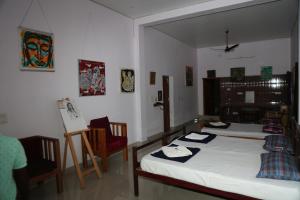 a bedroom with a bed and a table and chairs at Blissful Haven Art House - near entrance to Auroville in Auroville
