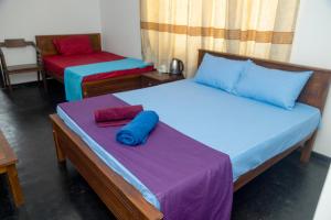 two beds sitting in a room with at Absolute Breeze by cherins in Matara