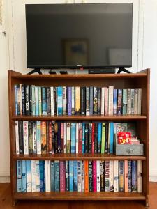 a book shelf filled with books and a television at Time & Again in Ceres