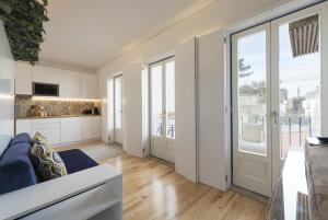 ein Wohnzimmer mit einem Sofa und eine Küche mit Glasschiebetüren in der Unterkunft S. Bento Downtown Apt in Porto