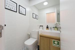 ein weißes Badezimmer mit Toilette und Waschbecken in der Unterkunft S. Bento Downtown Apt in Porto + 14 Fotos