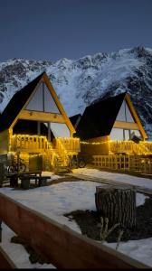 a building with lights in front of a mountain at Cottage Carpe Diem in Stepantsminda