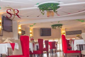een eetkamer met rode stoelen en tafels bij Selella Resort in Kisumu