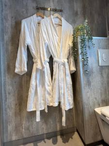 a white robe hanging on a wall in a bathroom at Vengsøy Rorbuer in Vengsøya +79 photos