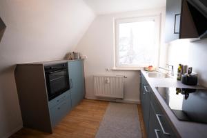 pequeña cocina con fregadero y TV en Meerjungfrau - W14, en Ulm