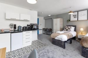 een keuken en een slaapkamer met een bed in een kamer bij City Centre Studio 6 with Kitchenette, Free Wifi and Smart TV by Yoko Property in Middlesbrough