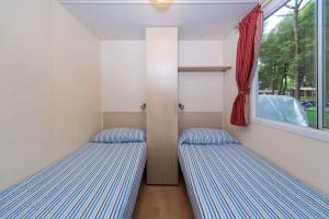 two beds in a small room with a window at Mobilehomes in Lido di Spina 21308 in Lido di Spina +14 photos