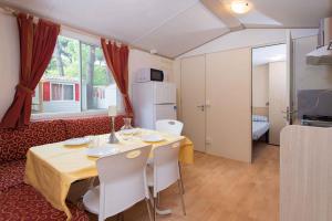 a living room with a table and chairs and a couch at Mobilehomes in Lido di Spina 21308 in Lido di Spina