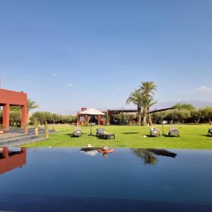a view of a pool of water with a house at DAR NOUJOUM in Marrakech