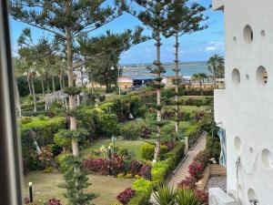 a view of a garden from the balcony of a resort at El-kobttan Chalet Sea Veiw - Maamourah in Alexandria