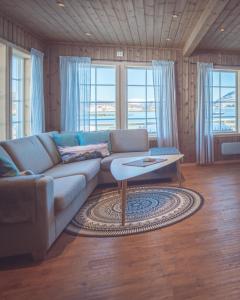 een woonkamer met een bank en een tafel bij Vengsøy Rorbuer in Vengsøya