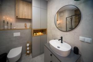a bathroom with a white sink and a mirror at Maya's Flats & Resorts 80 - Garnizon Gdansk in Gdańsk
