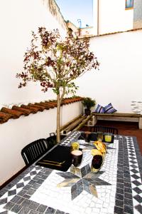 a table with a tree on a tiled floor at VUT Limoneros laranitasalmantina in Salamanca