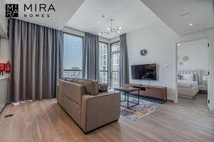 sala de estar con sofá, mesa y TV en Mira Holiday Homes - Lovely 1 bedroom in Midtown en Dubái