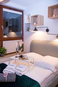 a bedroom with a bed and a table with towels at Maya's Flats & Resorts 80 - Garnizon Gdansk in Gdańsk