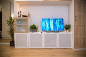 a living room with a tv on a white entertainment center at Maya's Flats & Resorts 80 - Garnizon Gdansk in Gdańsk