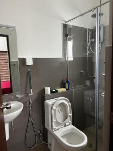 une salle de bain avec toilettes et lavabo dans l'établissement Canterbury Residence Garden Apartments, à Kahatuduwa