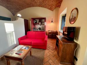 salon z czerwoną kanapą i telewizorem w obiekcie Le Serre Suites & Apartments w mieście Moncalieri
