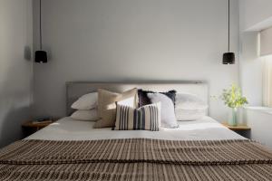um quarto com uma cama grande e almofadas em St Catherine's Hospital - Curated Property em Bath