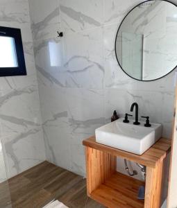 W łazience znajduje się umywalka i lustro. w obiekcie Cabaña Patagonia w mieście El Calafate