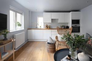 a kitchen with white cabinets and a table at St Catherine's Hospital - Curated Property in Bath
