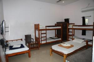 a room with several bunk beds and chairs at Blissful Haven Art House - near entrance to Auroville in Auroville