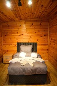 Vg Bungalow Sapanca في صبنجة: غرفة نوم بسرير في جدار خشبي