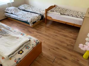 two beds in a room with wooden floors at Red Locomotive Apartment in Budapest