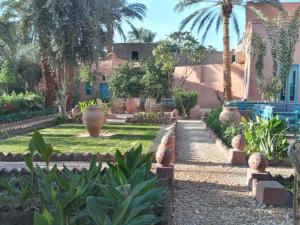 een tuin voor een huis met palmbomen bij Bab Al Samawy in Luxor