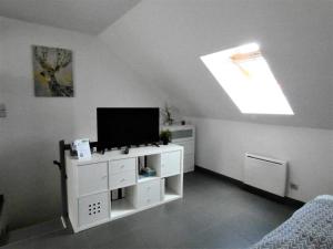 uma sala de estar com uma televisão de ecrã plano num armário branco em Grand studio centre historique Sancerre em Sancerre