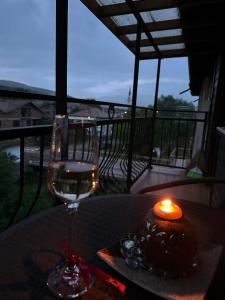 einen Tisch mit Kerzen und ein Glas Wein in der Unterkunft Къща за гости Арнаудови in Kostandovo