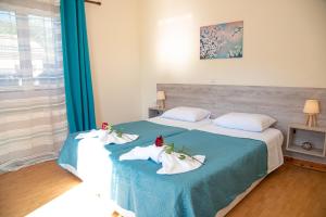 a bedroom with two beds with towels on them at Villa Kouros in Melíssia +42 photos